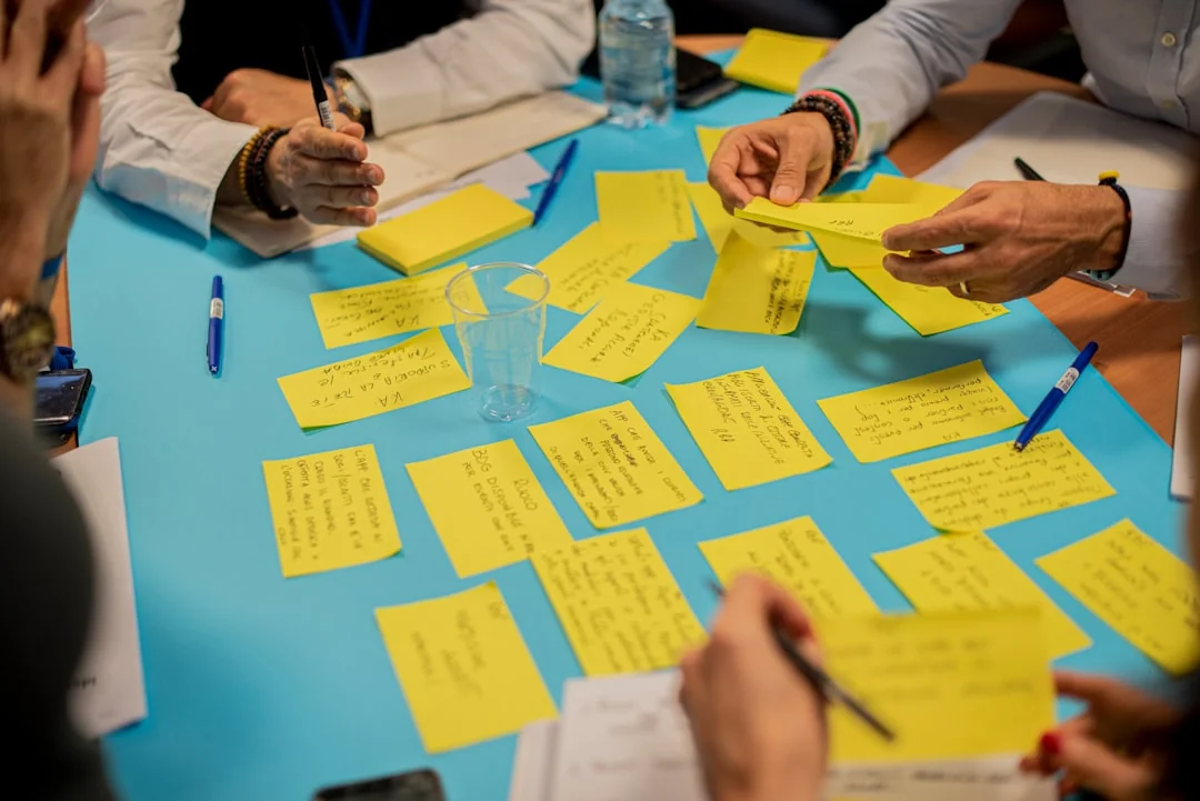 Two colleagues brainstorm ideas on a whiteboard during a creative strategy session.